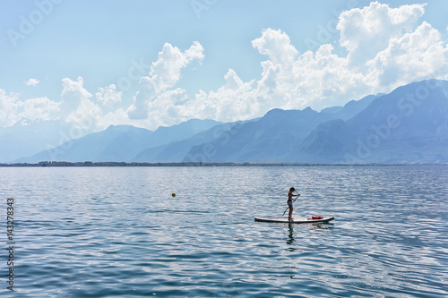 Girl standing standup paddle surfing Geneva Lake Montreux