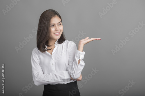 Beautiful Business Woman presenting something on grey background