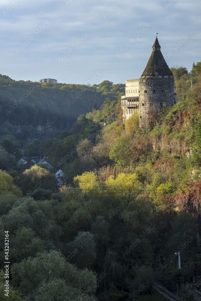 A watchtower above the canyon of the Smotrych River in Kamianets-Podilskyi, Western Ukraine. Trees are showing their autumn colours.