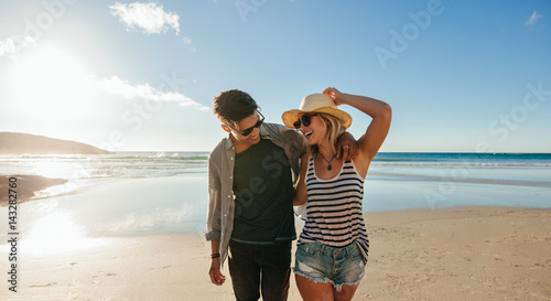 Couple walking on seashore and laughing