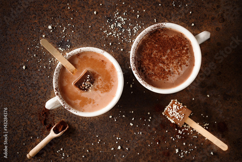 Twee kopjes warme chocolademelk met cacaopoeder Chocolade op stokje Bovenaanzicht