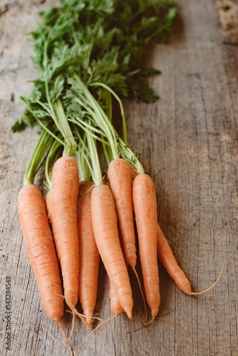 Fresh carrot on wooden background. Raw food, healthy eating concept.