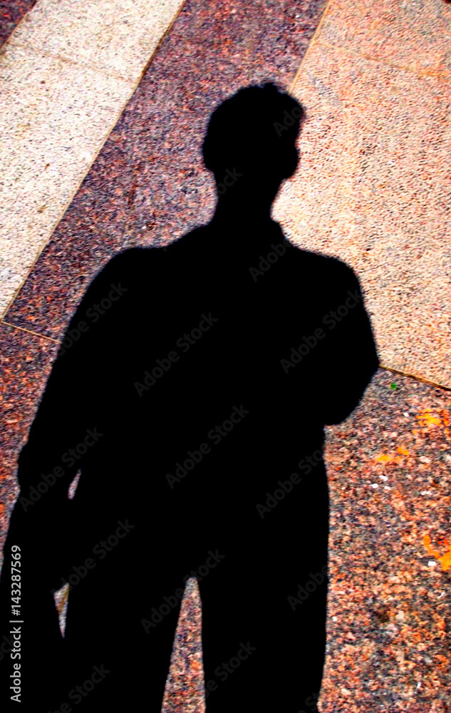 In the city there is a shadow from the sun on the granite pavement