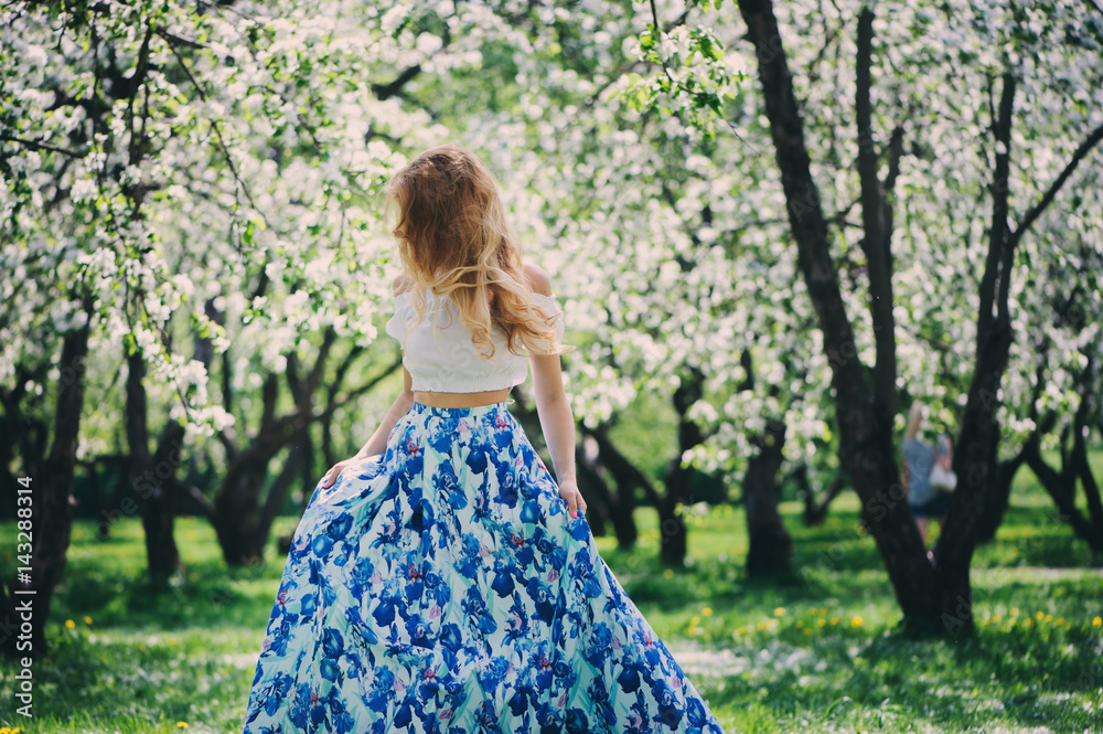 beautiful young woman in floral maxi skirt walking in spring beautiful young woman in floral maxi skirt walking in spring
