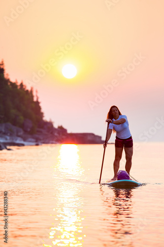 Attractive Young woman Stand Up Paddle Boarding, © Colin