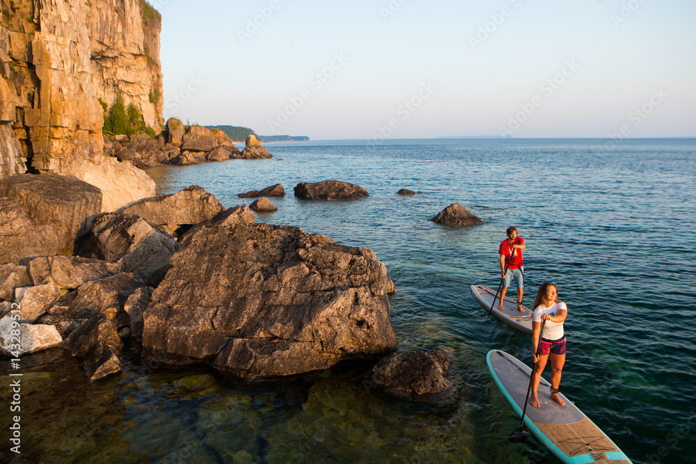 Attractive Young couple Stand Up Paddle Boarding
