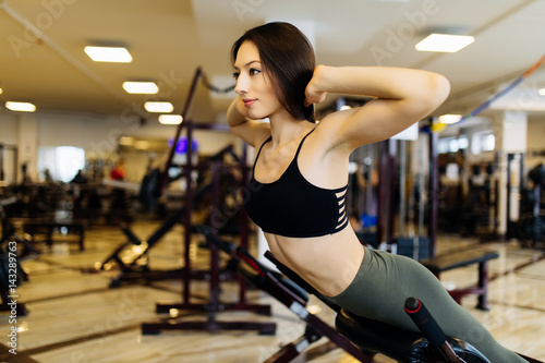 Young pretty woman workout on exercises machine in fitness gym
