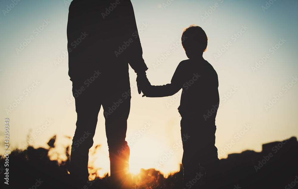 silhouette of father and son holding hands at sunset silhouette of father and son holding hands at sunset