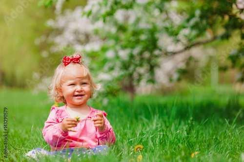 cute little girl with flowers in spring nature