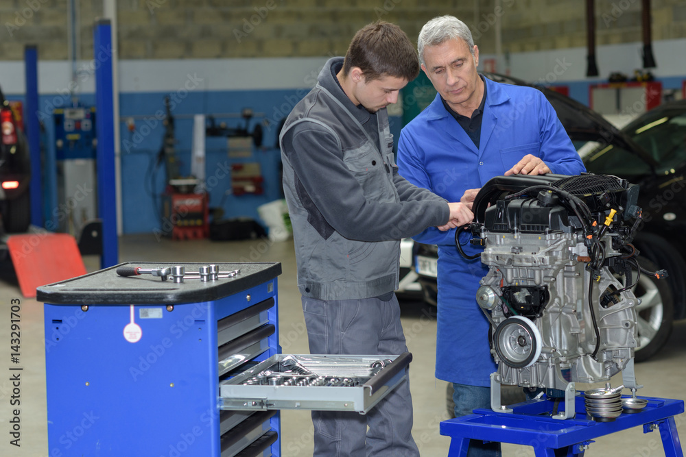student with instructor repairing a car during apprenticeship student with instructor repairing a car during apprenticeship