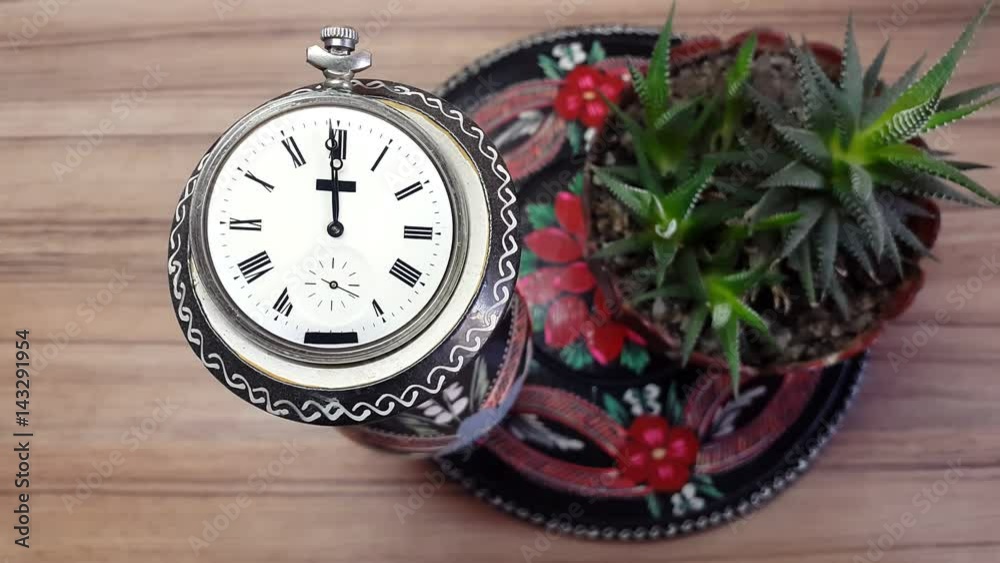 Clock in flower against the background of a wooden wall Clock in flower against the background of a wooden wall