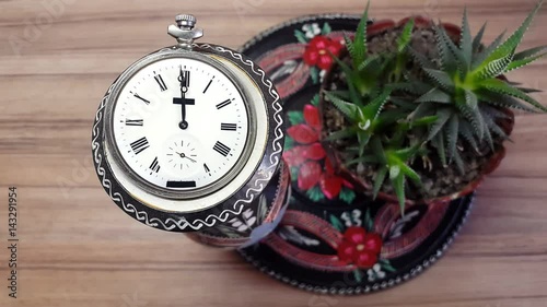 Clock in flower against the background of a wooden wall photo