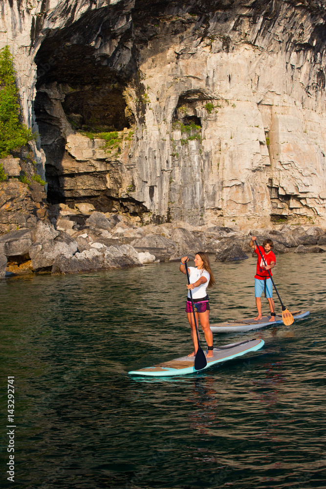 Attractive Young couple Stand Up Paddle Boarding
