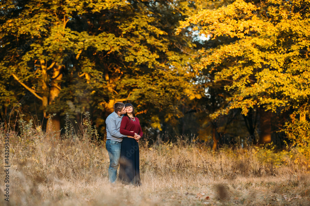 Lovers kiss on sunset in  forest