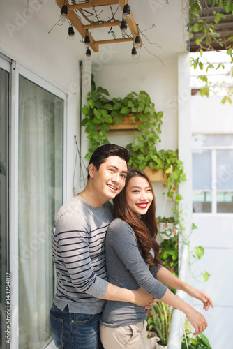 Couple in love sharing genuine emotions and happiness, hugging on the balcony © makistock