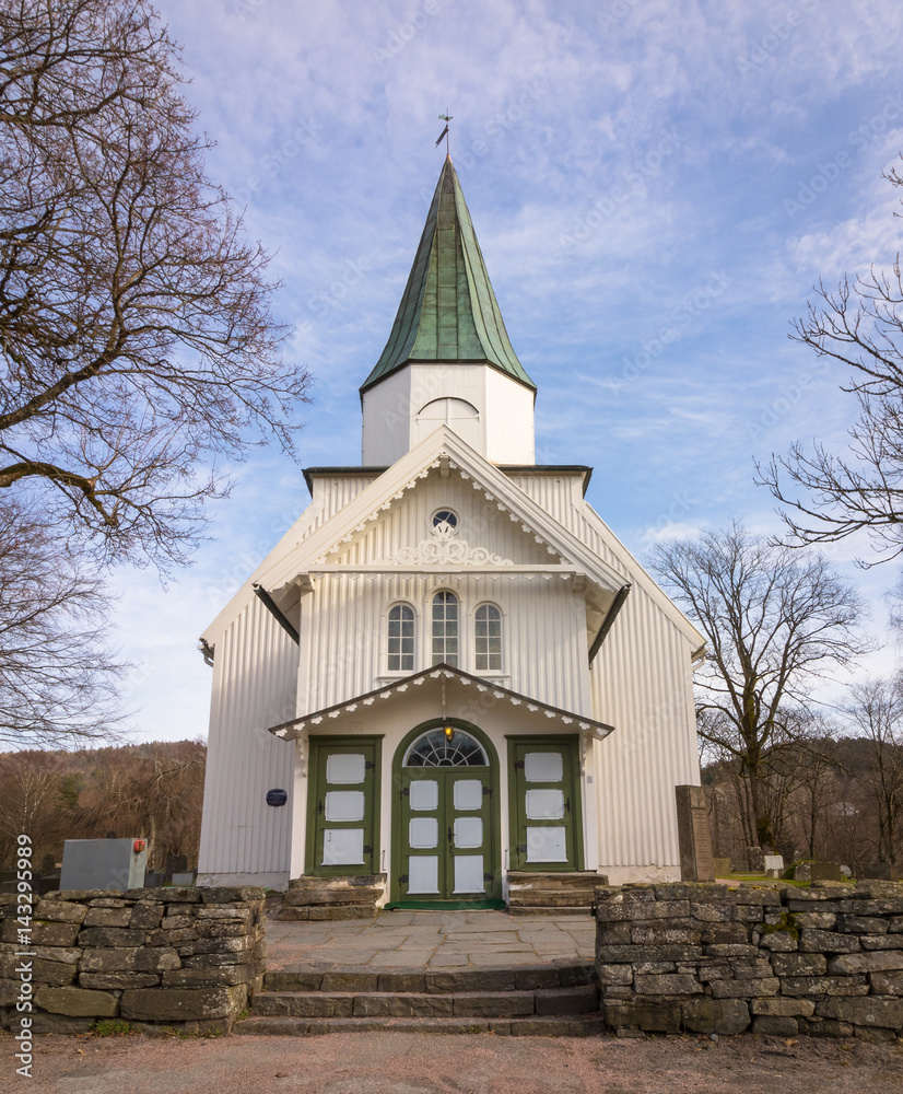 White church and blue sky with small clouds in Norway, vertical image