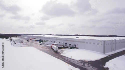Aerial Semi truck filling up at warehouse in the snow
