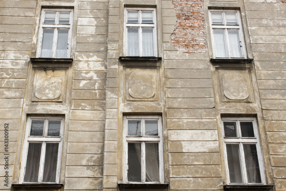 Obraz premium Six vintage white windows on the facade of the ragged old house
