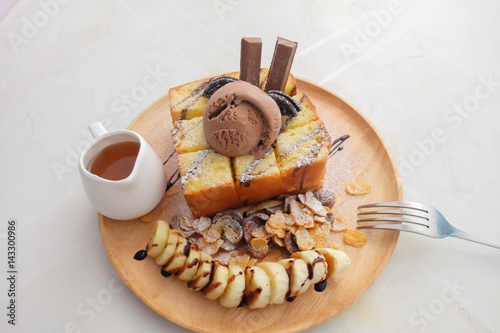 French toast with honey on the wooden plate.