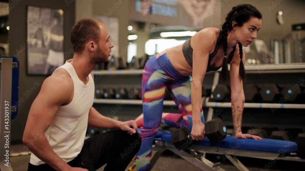 Man guiding woman lifiting weights Man guiding woman lifiting weights