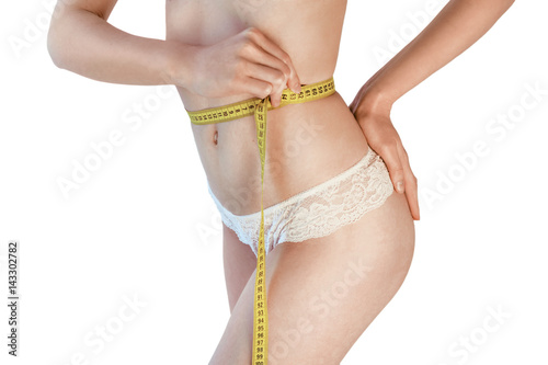 Woman measuring her waistline. Perfect Slim Body. Diet. Young girl measuring waist with a white background