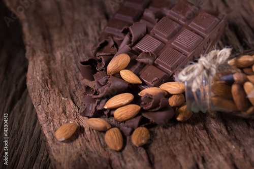 Chocolate bar pieces. large bar of chocolate and Almond nuts on wooden background