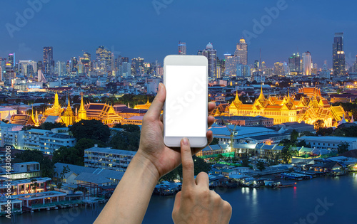 Photography Hands touching smartphone in front of temple of emerald buddha, grand palace at