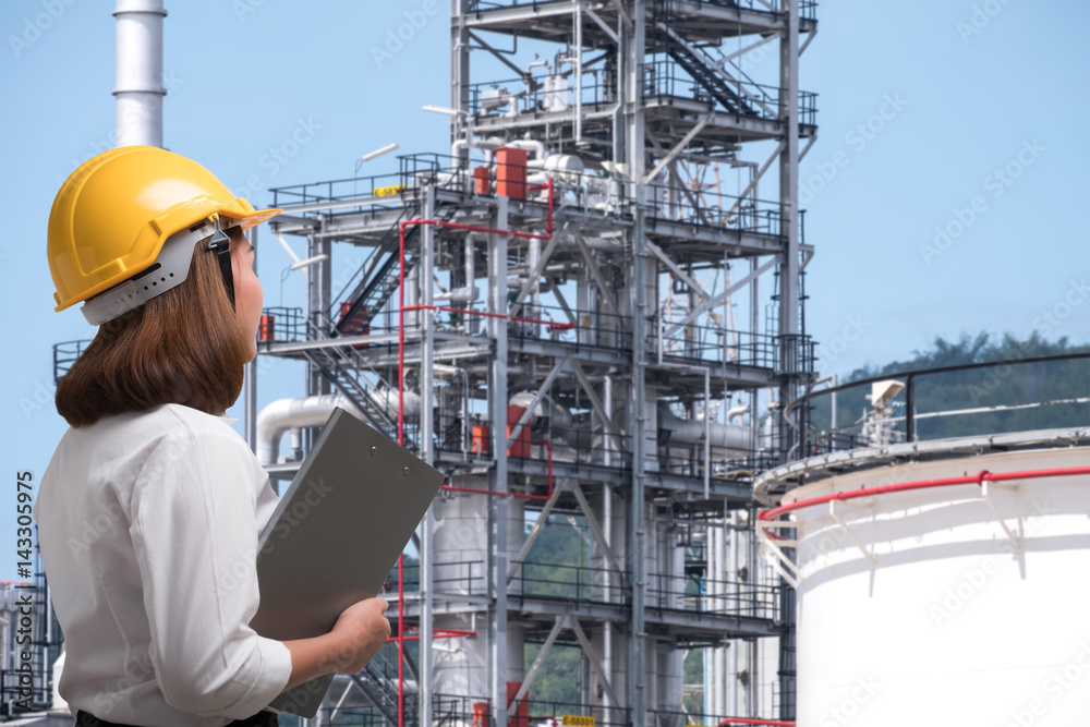 Female engineer wearing safety helmet inspects pipeline industry site Female engineer wearing safety helmet inspects pipeline industry site