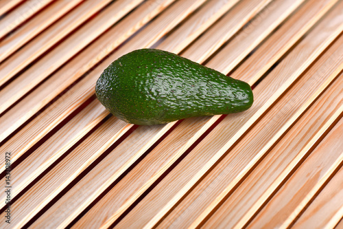 fresh green avocado on brown wooden table, sparcling background photo