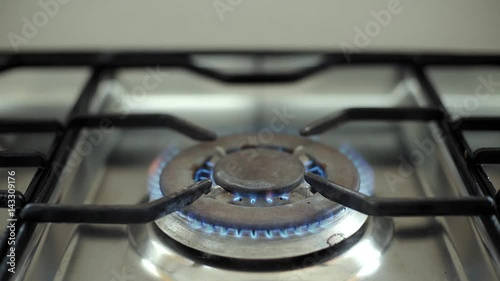 Common top view on central hob of professional industral steel made gas cooker with burning blue flame photo