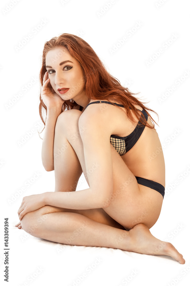 attractive young redhead woman in blue underwear sitting on floor. attractive young redhead woman in blue underwear sitting on floor. Isolated on white.