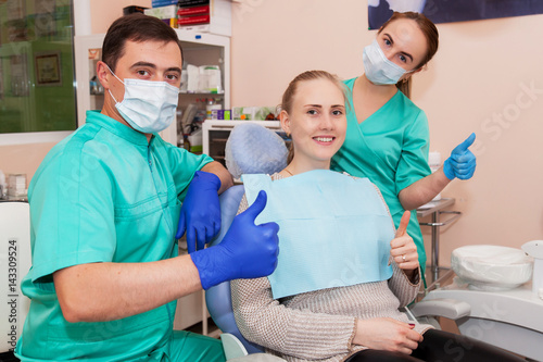 Happy two dentists and a patient, after dental treatment