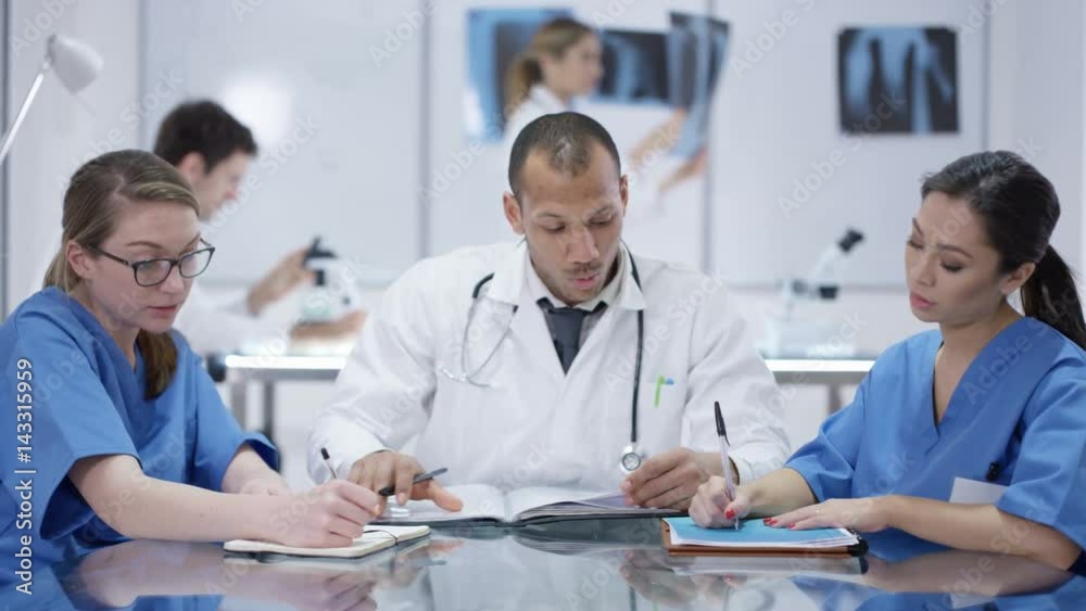 Medical team in a meeting with colleagues working in background Medical team in a meeting with colleagues working in background