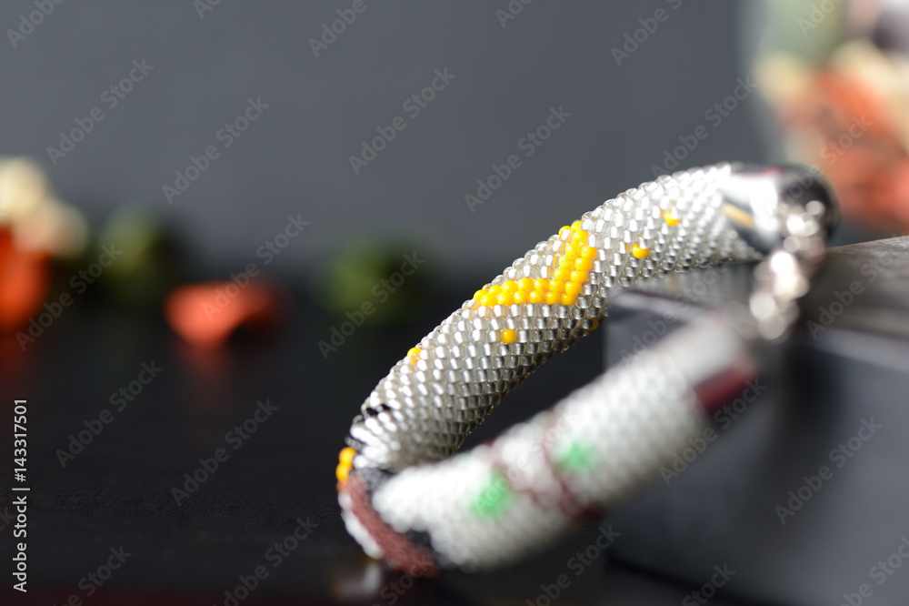 Obraz premium Handmade Beaded Crochet Bracelet with Owl on a dark background