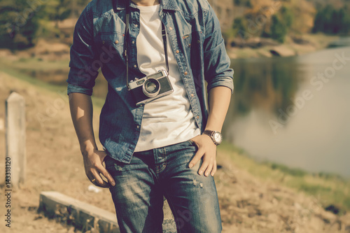 Young man tourist standing and taking photos with vintage camera.