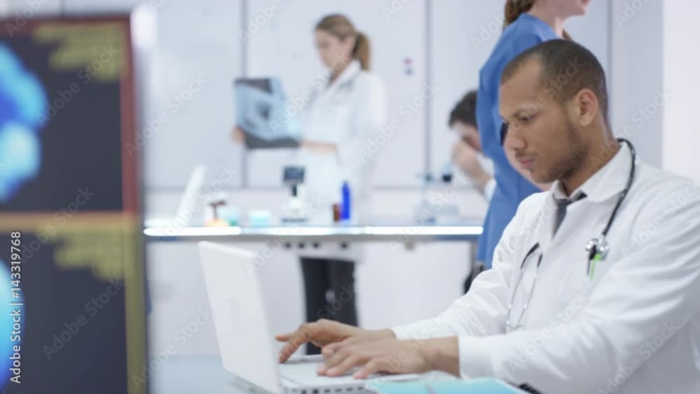 Medical team working together, using technology & looking at x-rays Medical team working together, using technology & looking at x-rays