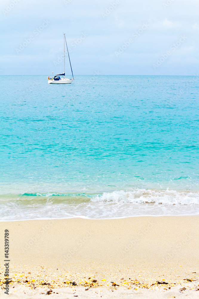 Sailing boat anchored at the seashore, turquoise water and yellow sandy beach, copy space, background texture. Summer sun vacation concept. Sailing boat anchored at the seashore, turquoise water and yellow sandy beach, copy space, background texture. Summer sun vacation concept.