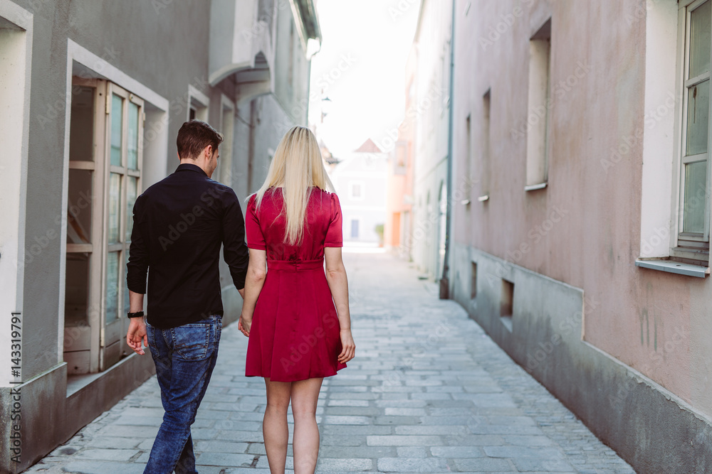 Verliebtes Paar in Altstadtgasse mit rotem Kleid