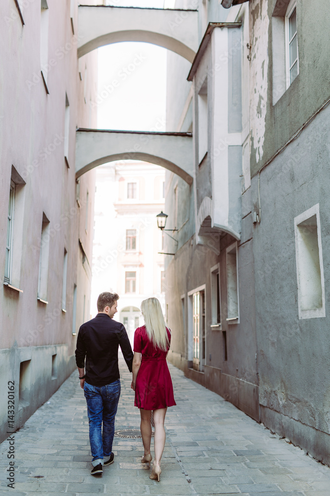 Verliebtes Paar in Altstadtgasse mit rotem Kleid