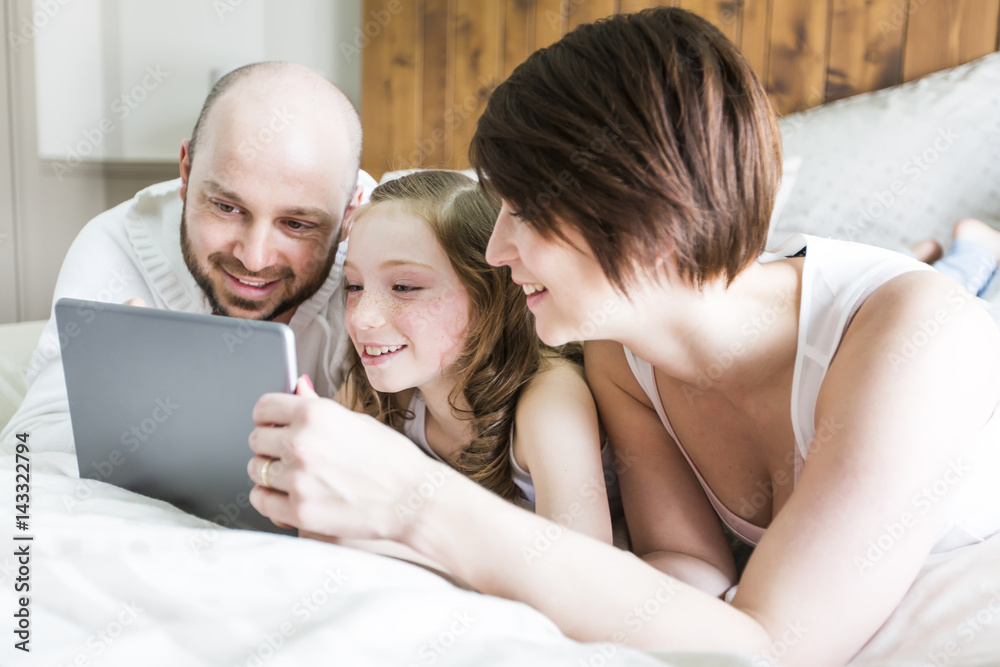 Mother father and her child with digital tablet relaxing at home Mother father and her child with digital tablet relaxing at home