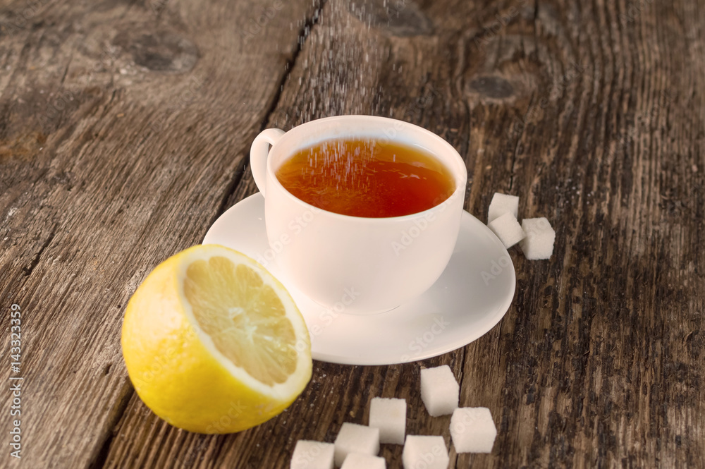 sweet cup of fruit tea with lemon and sugar on a wooden background sweet cup of fruit tea with lemon and sugar on a wooden background