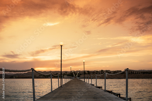 Fototapeta Naklejka Na Ścianę i Meble -  Langer Steg übers Meer im Sonnenuntergang