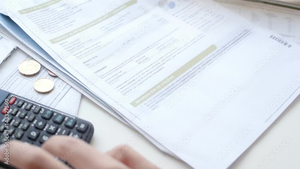 Close up focus on woman hands is using scietific calculator to check total sum of household bills Close up focus on woman hands is using scietific calculator to check total sum of household bills