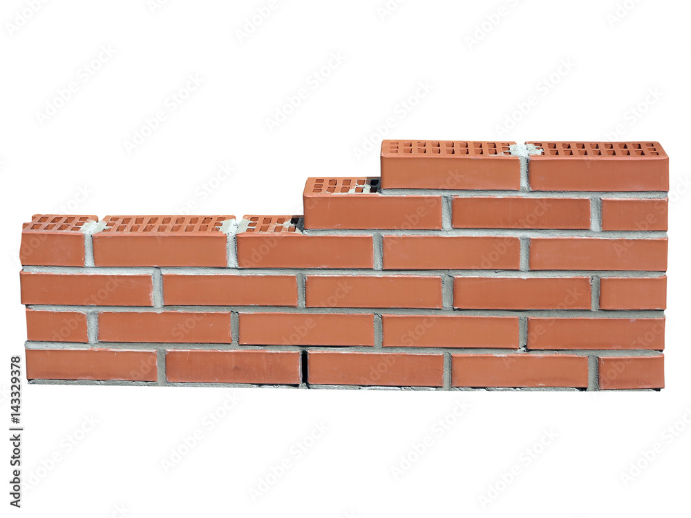 Obraz premium New red brick wall in construction process isolated on white