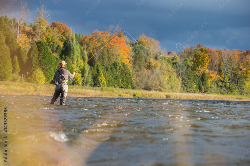 Man fly fishing in the fall in a river