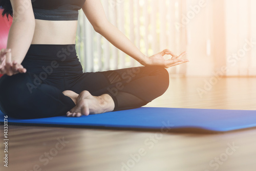 Young Asian woman practicing yoga. Girl is meditating. Copy space.