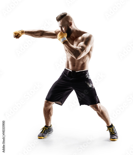 Muscular male in sports clothes сonducts fight with shadow. Photo of boxer on white background. Strength and motivation