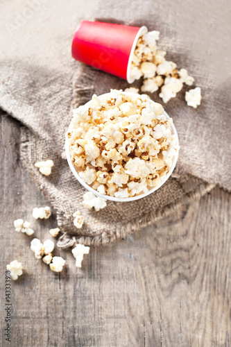 Homemade Kettle Corn Popcorn on wooden background - cinema, movies and entertainment concept.