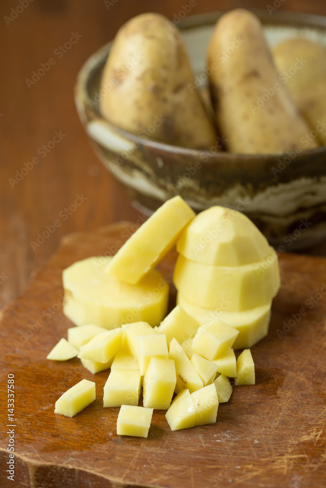 Potatoes and potato sliced on wooden table. Selective focus Potatoes and potato sliced on wooden table. Selective focus