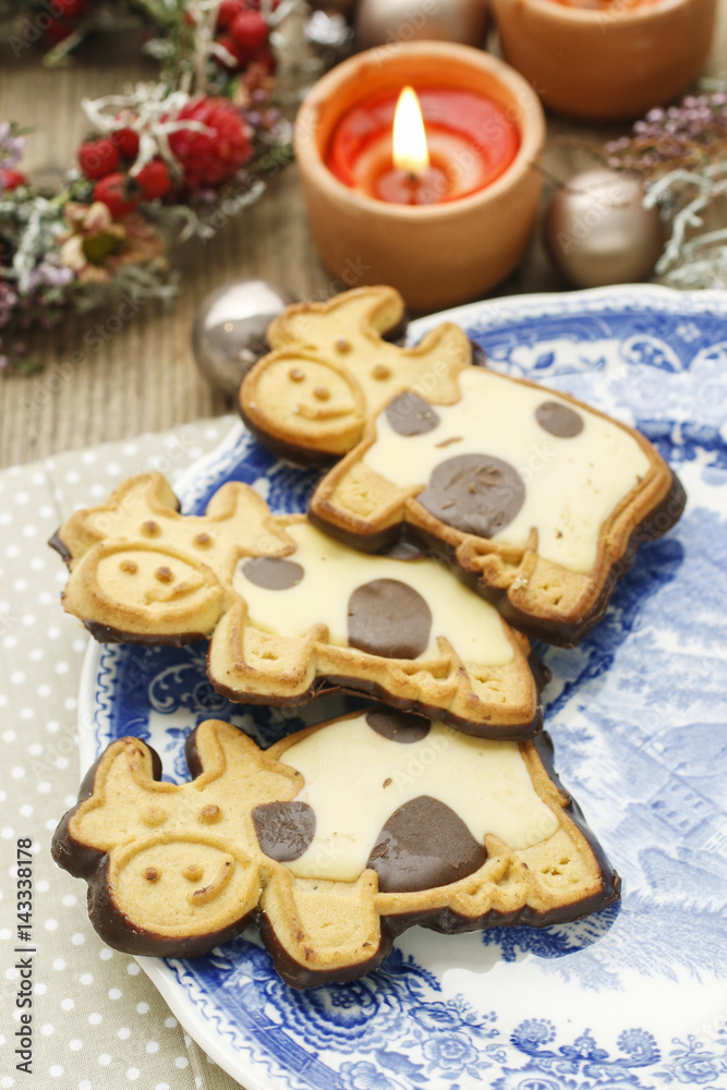 Funny cookies in cow shape decorated with dark and white chocolate icing.